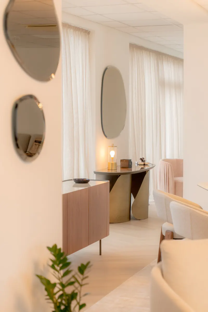 Pohľad cez showroom Pooza s organickými zrkadlami a krémovým interiérom